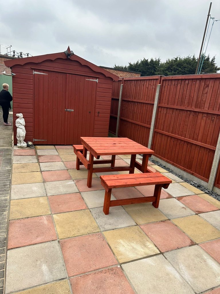 Tidied back garden with fresh stained picnic bench and clean paving